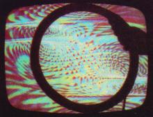 Groovy color patterns on a monitor with a magnetic disk distorting the video image