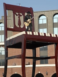 Chuck Brown strums his guitar while standing on Anacostia's Big Chair.