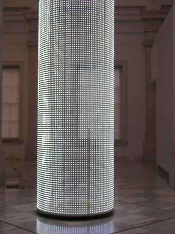 Cylindrical tower made of lights displaying text