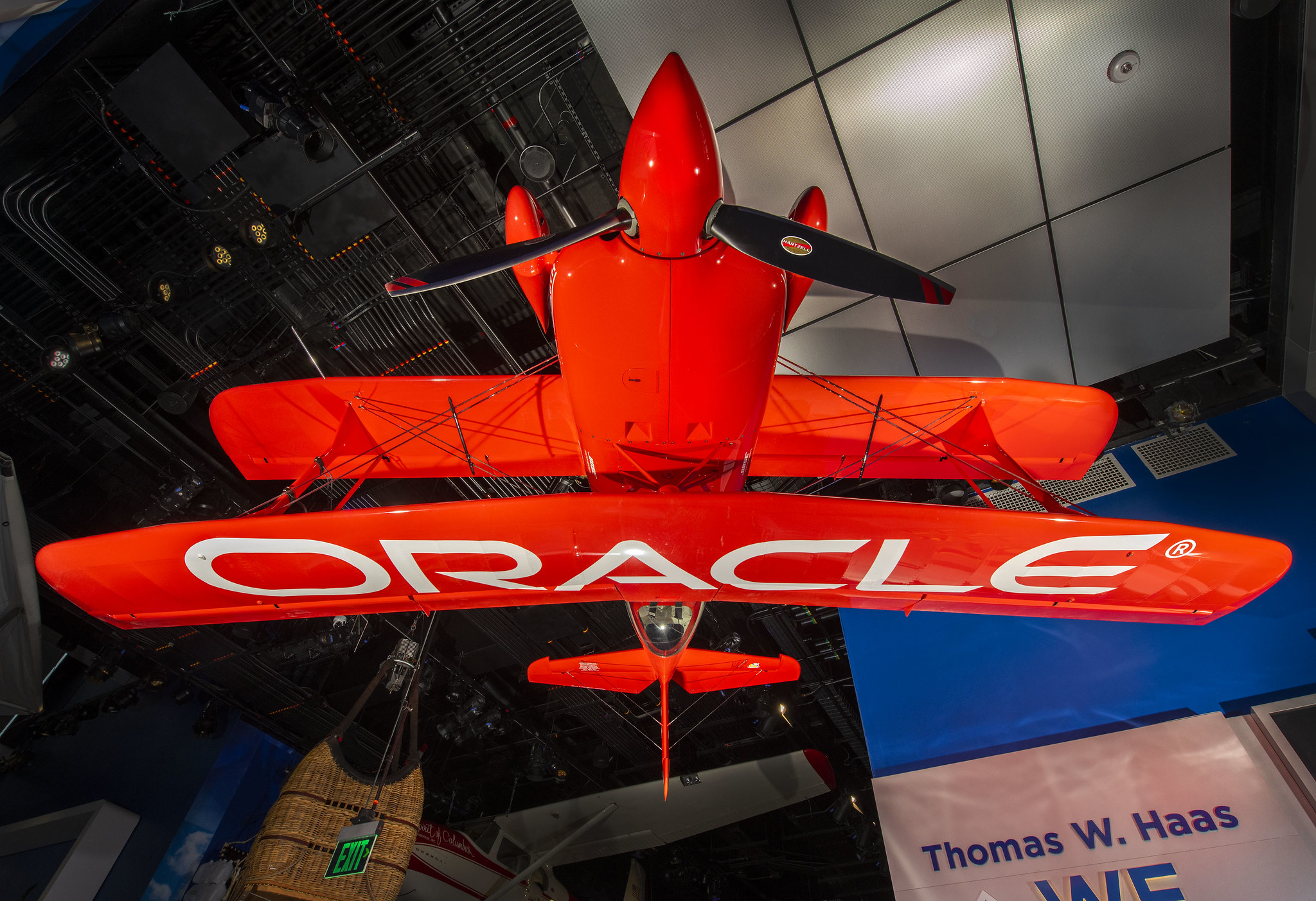Bright red airplane with "Oracle" written on wings, hanging upside down