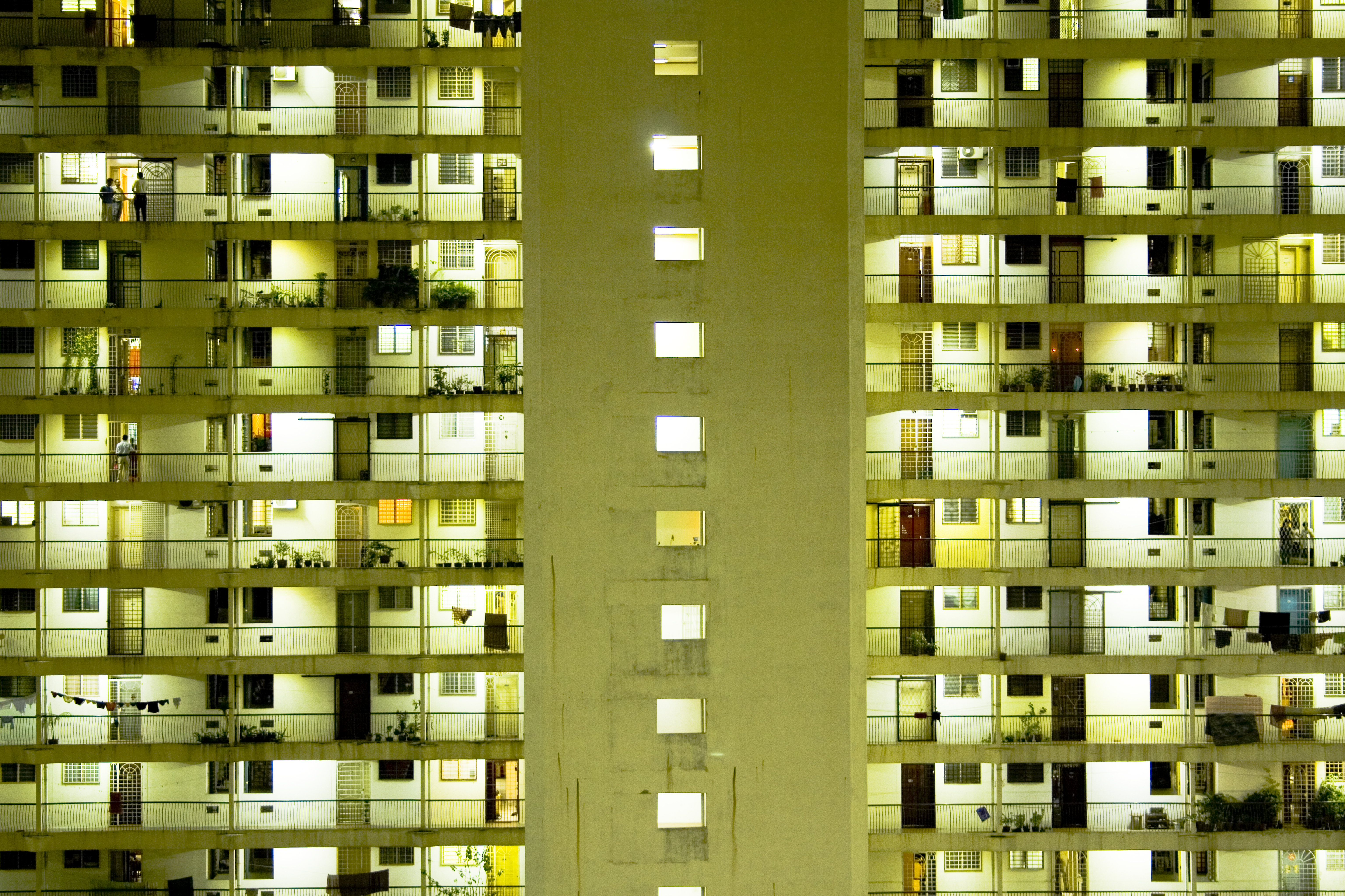 View of large apartment building exterior lit up at night