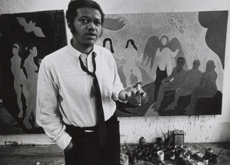 Man (Bob Thompson) standing in front of paintings