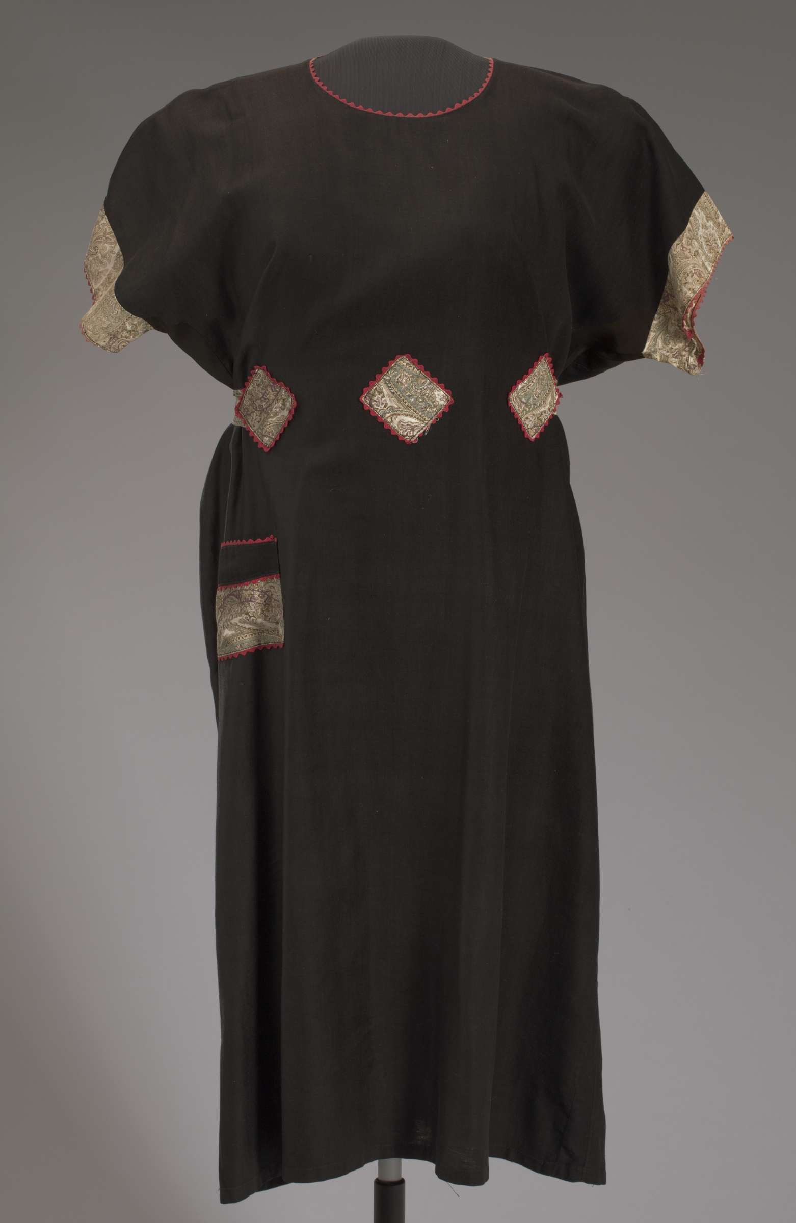 Long black frock with red emroidered detail around neckline.
