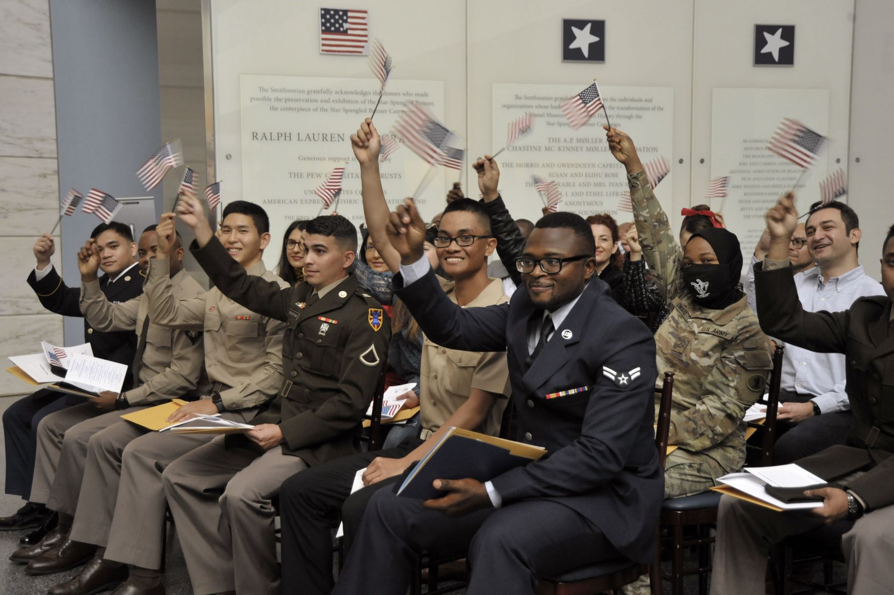 Group of people sitting in chairs while waving mini American flags