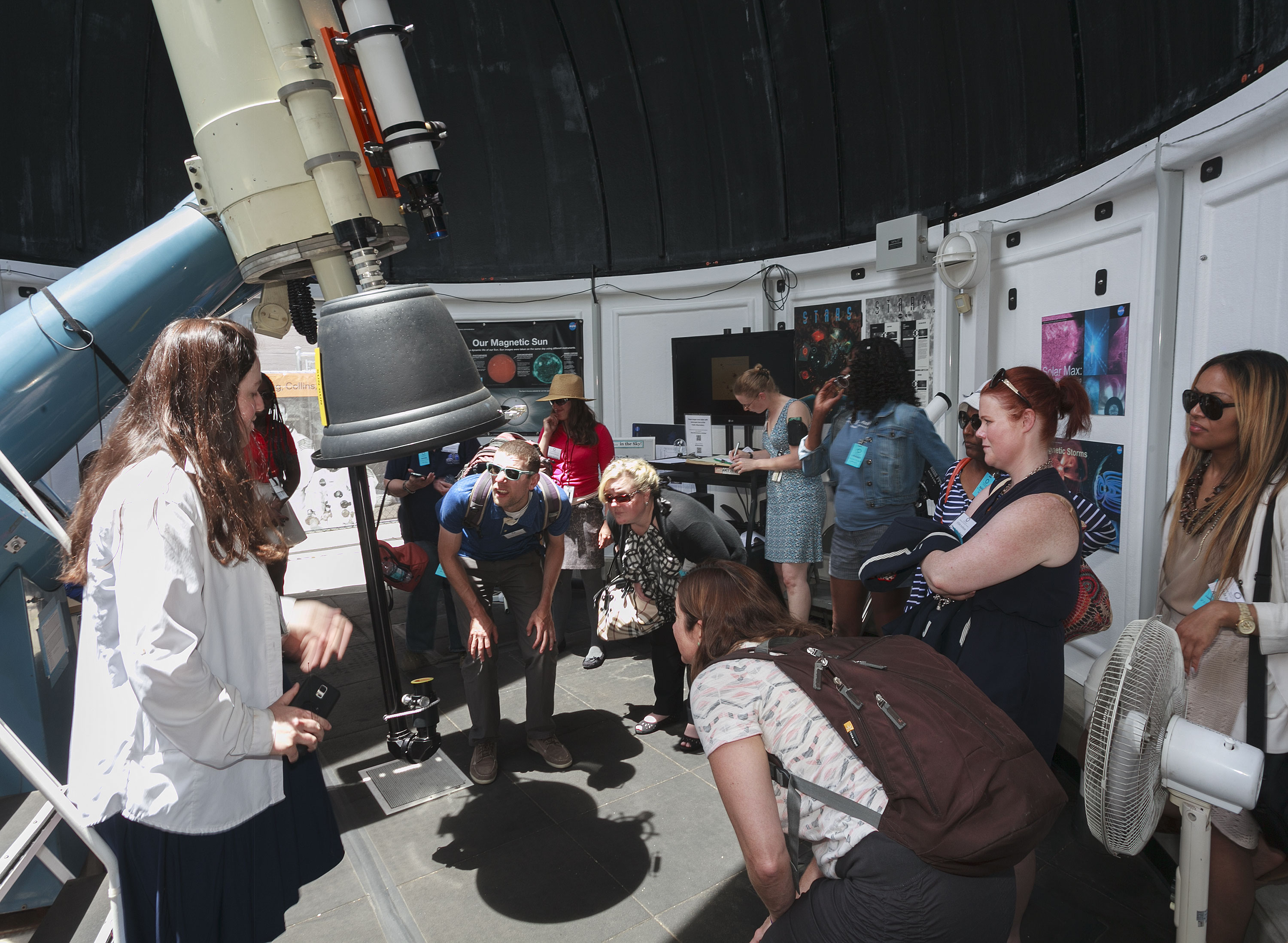 Group gathers around telescope