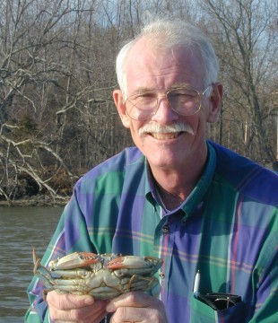 portrait of Hines holding a blue crab