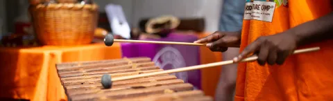 Hands from a young person hold drumsticks. 