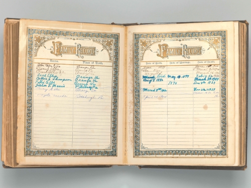 Book open to pages for family records with handwritten names and dates
