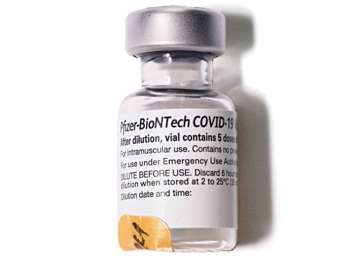 Small glass vial with label for Pfizer-BioNTech COVID-19 vaccine.