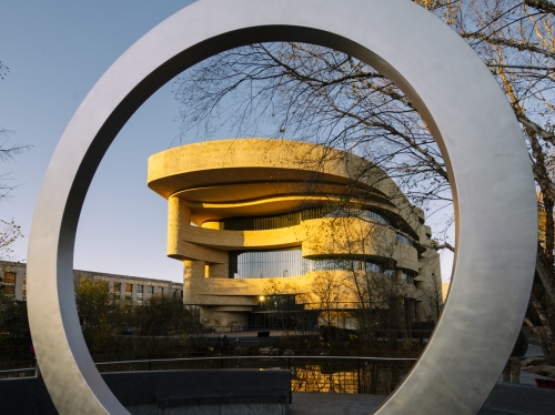 Exterior of National Museum of American Indian seen through circular sculpture of the veterans memorial