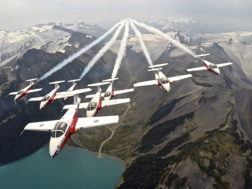 Canadian military planes in formation over mountains