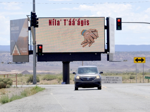 Car drives in front of billboard