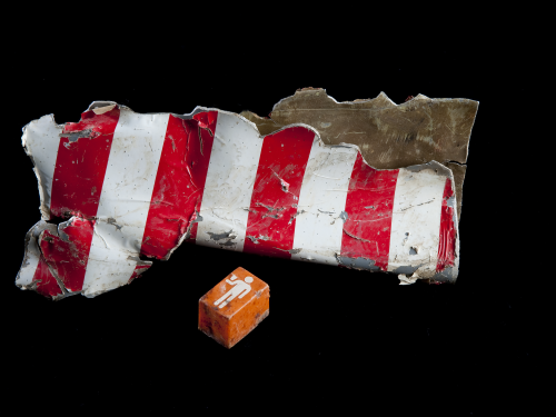 Fragment of red-striped wreckage and orange call button