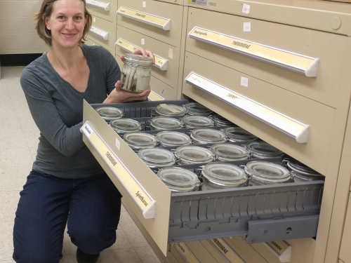 Researcher Hannah Wood holds jar with specimens
