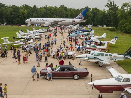 Visitors look at airplanes parked on runway