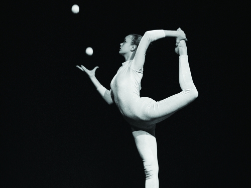 Black and white photo of woman in yog pose juggling