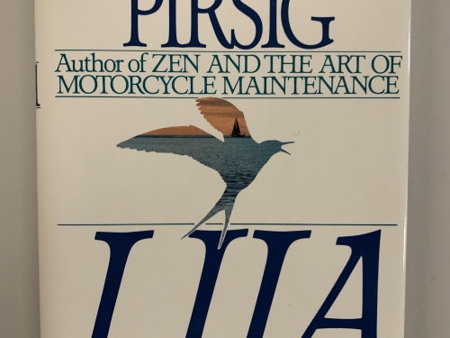 Front cover of book, white with large blue and green typefont and a multicolored bird with wings up in the center