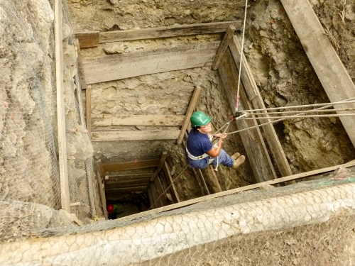 researcher descending into excavation