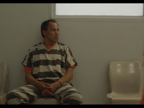 Still from film Mekko, showing man in jail cell
