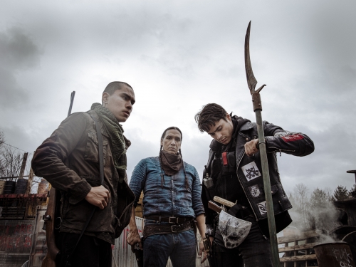 Three armed Native men, one staring into camera