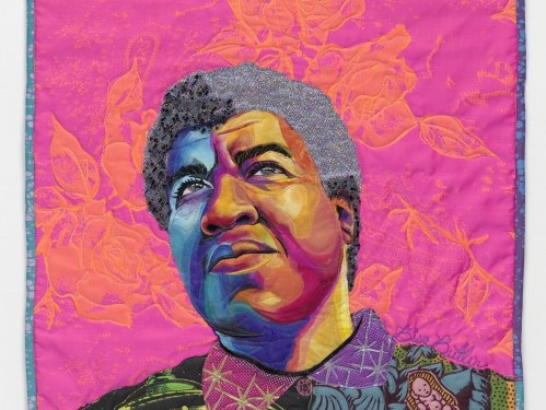Bright pink quilt with womans face, eyes gazing upward.
