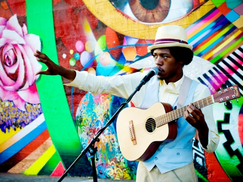 Musician in front of colorful mural