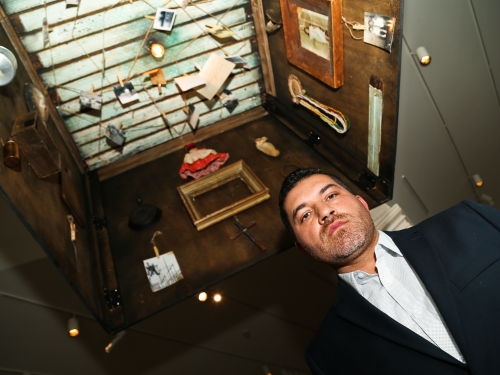 Artist standing beneath his installation