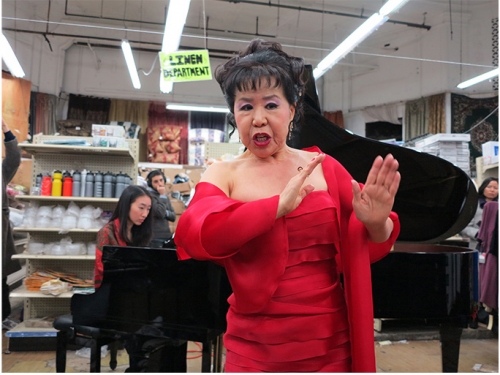 Asian woman in red dress in front of grand piano