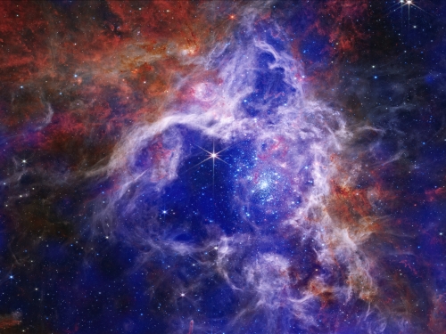 Image of outer space with bright stars and clouds of purples and blues.