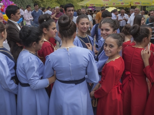 Costumed girls gather before a dance, one smiles at camera