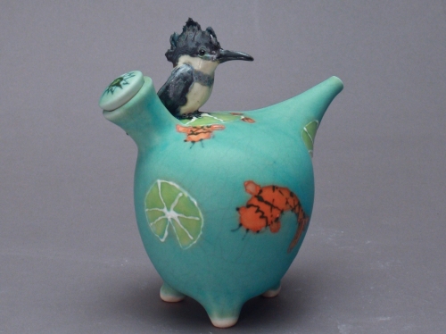 Turquoise-colored ceramic with painted small orange koi fish and a slice of lime, small gray and white bird on top.