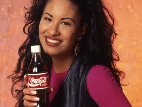 Singer Selena posing with bottle of Coke