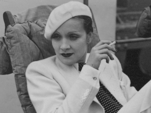 Marlene Dietrich wearing white beret and smoking