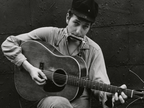 young Dylan with guitar and harmonica