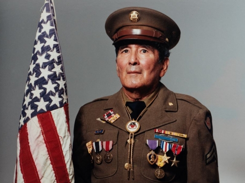 Official portrait of man in military uniform holding an American flag