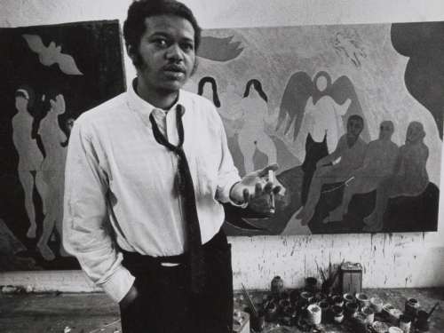 Man (Bob Thompson) standing in front of paintings