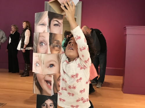 Child building a tower with photo blocks