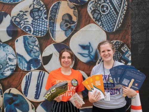 Volunteers holding fans and brochures at the Folklife Festival