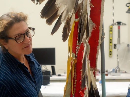 Conservator looking at headdress.