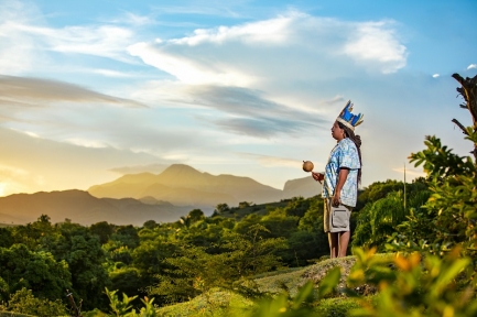 Man in tribal headgear overlooking mountains