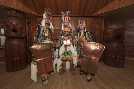 Costumed dancers carrying shields