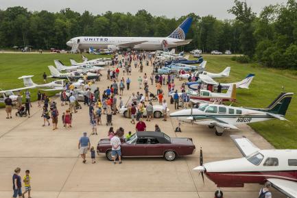 Visitors look at airplanes parked on runway