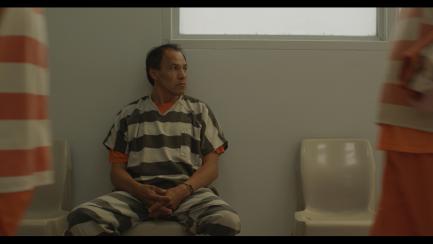 Still from film Mekko, showing man in jail cell