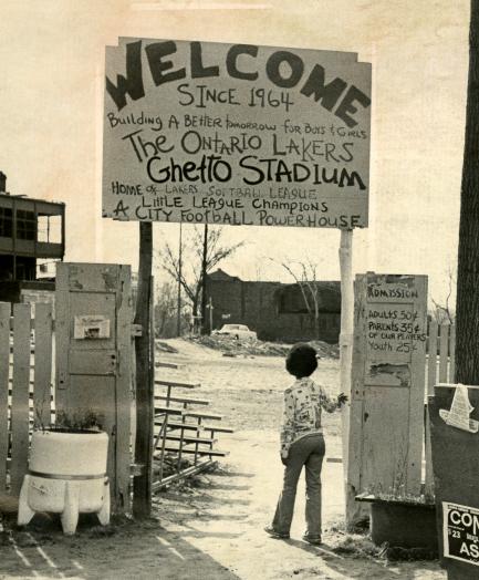 Child stands beneath welcome sign