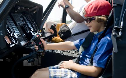 Child wearing red cap in airplane cockpit