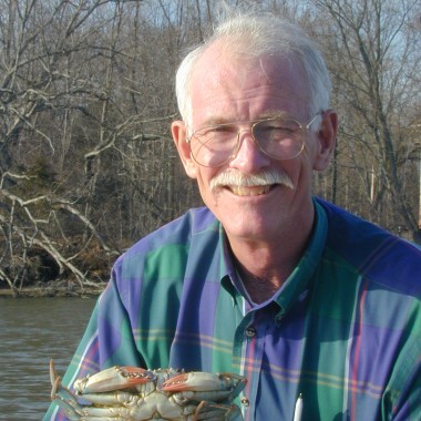 portrait of Hines holding a blue crab